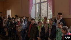 Los niños se reúnen en una escuela durante su evacuación al oeste de Ucrania, desde la ciudad sureña de Jersón, el 30 de octubre de 2023, en medio de la invasión rusa de Ucrania.