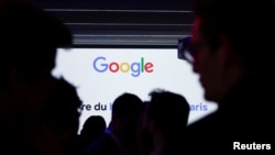 Siluetas de personas frente al logotipo de Google durante la inauguración de un nuevo centro en Francia dedicado al sector de la inteligencia artificial (IA), en la sede de Google Francia en París, el 15 de febrero de 2024.