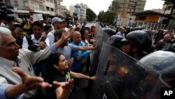 Para polisi Venezuela menghalangi massa untuk berpawai memprotes pemerintahan Presiden Nicolas Maduro, di Caracas, Venezuela, 9 Maret 2019.