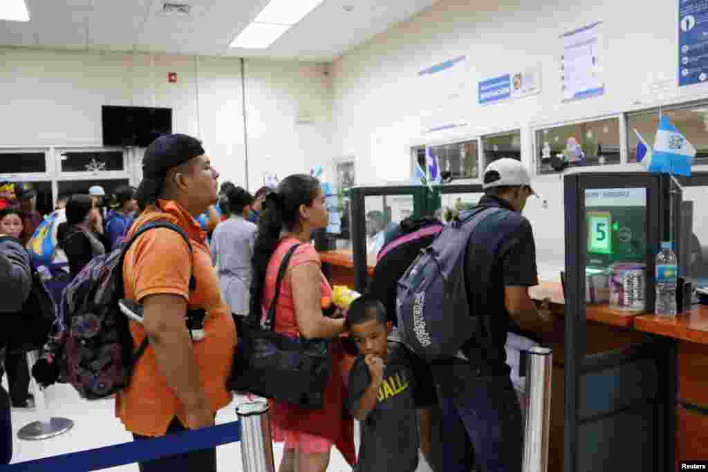 Los hondureños esperan ser registrados por un funcionario de inmigración en la frontera entre Honduras y Guatemala. 