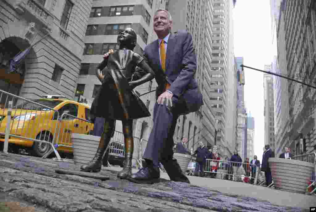 2017年3月27日,纽约市长白思豪(Bill de Blasio)在举行新闻发布会前和无畏女孩像合影。在华尔街奔牛铜像和无畏女孩像之争中,纽约市长白思豪(Bill de Blasio)支持无畏女孩,决定把女孩像在铜牛前面放到2018年2月底。