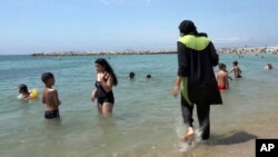 Une femme couverte de burkini joue sur la plage, à Marseille, au sud de la France, 4 août 2016. 
