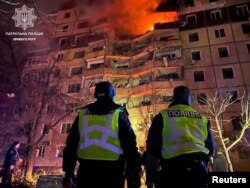 Policajci stoje ispred stambene zgrade oštećene u ruskom raketnom napadu, tokom ruske invazije na Ukrajinu, u Krivom Rogu, 12. marta 2024.