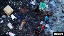 FILE - Plastic and other waste is seen floating on the Marine Lake at New Brighton beach near Liverpool, England, Feb. 11, 2019.
