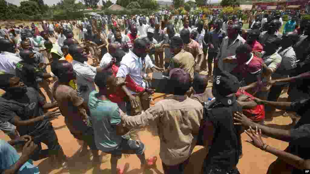 Confrontation entre les Ougandais et les policiers après avoir attendu plus de 7 heures sans être en mesure de voter dans un bureau de vote dans Ggaba, les forces de l'ordre ont mal à garder la main sur une boîte contenant les matériel électoraux,en Ouganda jeudi 18 février