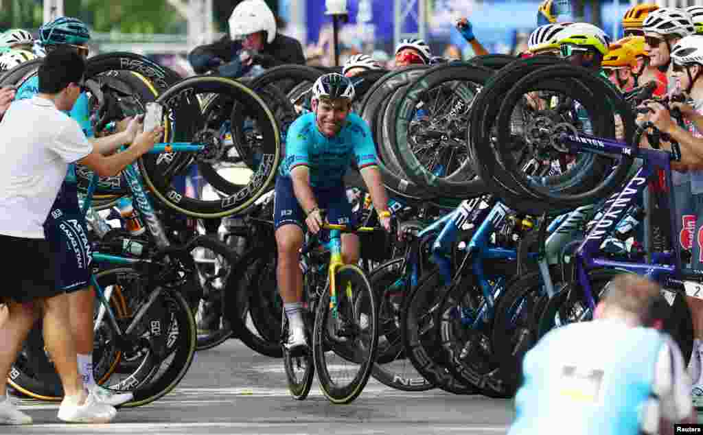 Cyclists honor Astana Qazaqstan Team's Mark Cavendish to mark his retirement before the start of the third Tour de France Singapore Criterium race in Singapore.