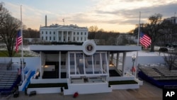 Trabajadores continúan con los toques finales al estrado de revisión presidencial en Pennsylvania, afuera de la Casa Blanca, el jueves 16 de enero de 2025, en Washington, antes de la toma de posesión del presidente electo Donald Trump.