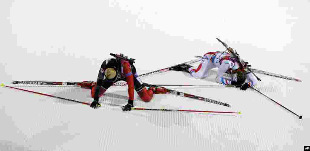 Canada's Zina Kocher, left, and France's Anais Bescond lies on the snow after completing the women's biathlon 7.5k sprint, in Krasnaya Polyana, Russia, Feb. 9, 2014.