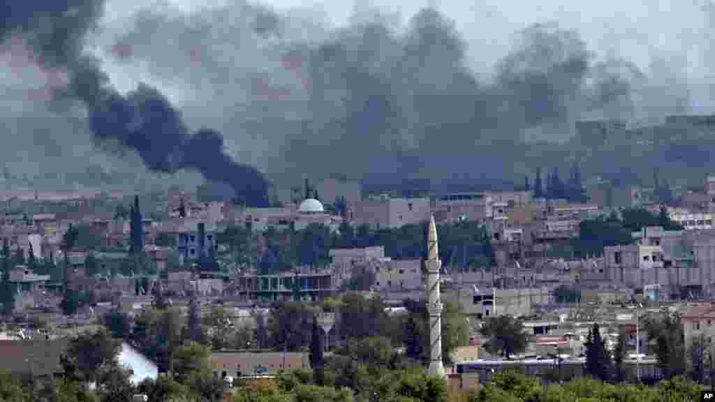 Smoke rises above the Syrian town of Kobani during fighting between Islamic State and Kurdish forces, seen from a hilltop on the outskirts of Suruc, Turkey, near the Turkey-Syria border, Oct. 26, 2014.