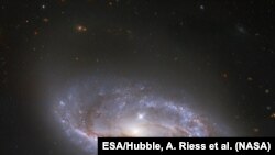 资料照片：美国宇航局/欧空局哈勃太空望远镜深入宇宙瞥见的无数的臂状结构，这些结构横跨这个被称为NGC 2608的螺旋星系。(美国宇航局提供)