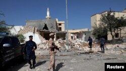 ARCHIVES - Des membres de la sécurité libyenne inspectent le site d'une frappe aérienne de nuit, qui a touché un quartier résidentiel à Tripoli, en Libye, le 14 octobre 2019. 
