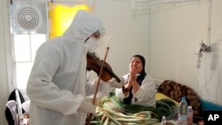 Le Dr Mohamed Salah Siala joue du violon pour les patients des services COVID de l'hôpital Hedi Chaker à Sfax, dans l'est de la Tunisie, le samedi 20 février 2021.