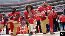Foto tomada en octubre del año pasado en el estadio de los San Francisco 49ers: hincados Eli Harold, Kaepernick y Eric Reid .