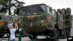 在北京軍事博物館，兒童給中程防空導彈發射器和運載車拍照（2017年7月27日）。為紀念中國人民解放軍（People's Liberation Army）建軍90週年，北京軍事博物館展覽了一些新式武器。