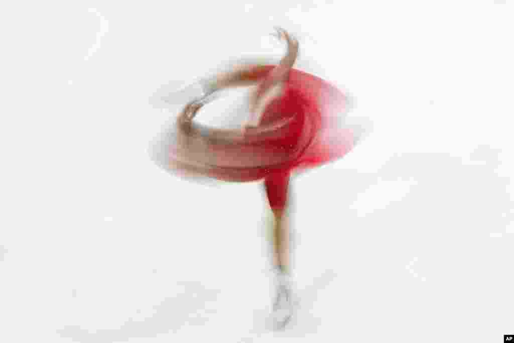 هنرنمایی یک ورزشکار استونیایی هنگام رقابت رقص روی یخ در شهر میلان، ایتالیا . 