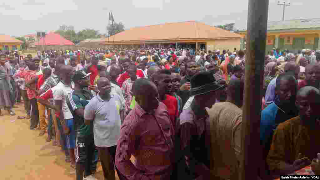 Des centaines de Nigérians font la queue devant un bureau de vote à la périphérie de la capitale Abuja, en attendant de voter lors de l’élection présidentielle du 28 mars 2015.