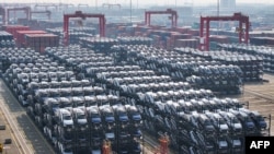 Makinat elektrike në pritje për t'u ngarkuar në anije në portin kinez Taicang, në Suzhou, Kinë (8 shkurt 2024)