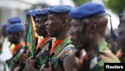 Des soldats ivoiriens au cours d'une cérémonie en l’honneur de leurs camarades miliaires tués lors d’une attaque djihadiste sur la station balnéaire de Grand Bassam, à Abidjan, 8 avril 2016. 