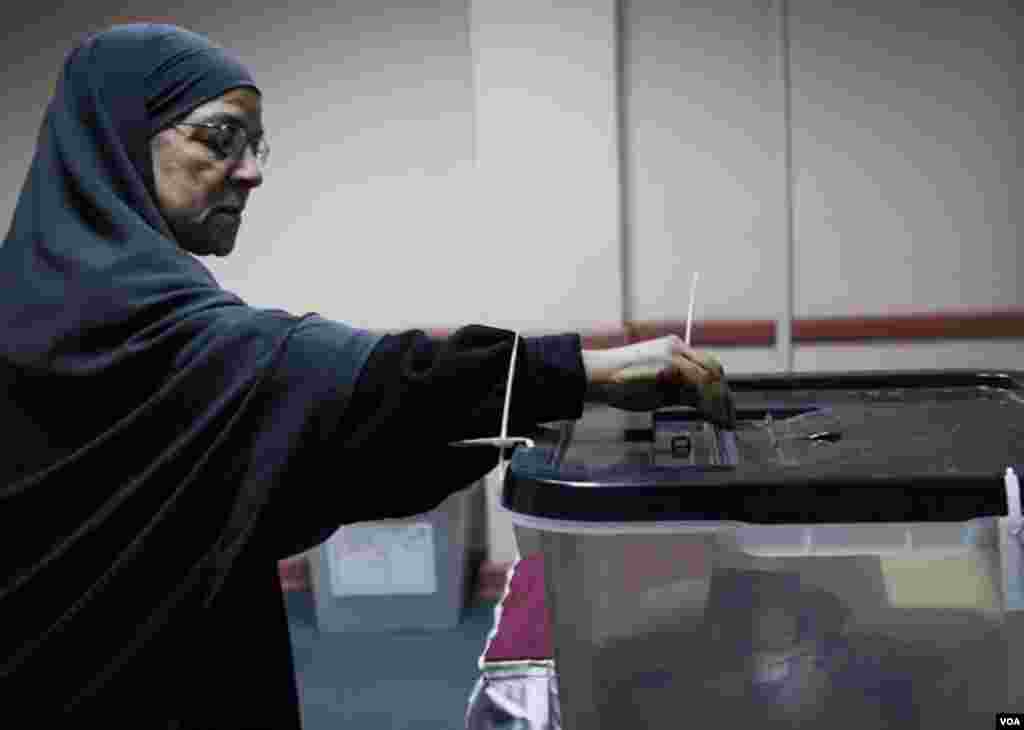 Seorang perempuan memasukkan kertas suara di Giza (22/12). (VOA/Yuli Weeks)