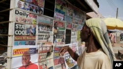 Un homme regarde les journaux locaux dans une rue d'Accra, au Ghana, le 9 décembre 2016. (AP Photo/Sunday Alamba)