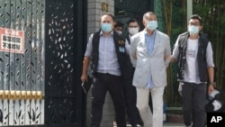 FILE - Hong Kong media tycoon Jimmy Lai, center, who founded local newspaper Apple Daily, is arrested under the new national security law by police officers at his home, Aug. 10, 2020. Lai was arrested on suspicion of collusion with foreign powers.