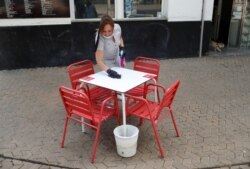 Una imagen que ilustra el alivio de los confinamientos en España. Una camarera limpia una mesa solitaria de un restaurante en Sevilla el 11 de mayo de 2020.