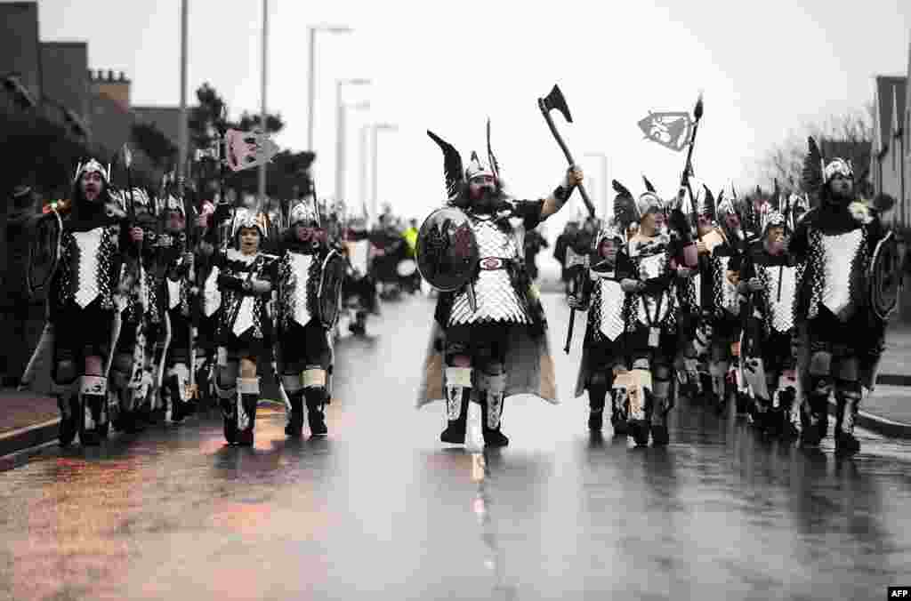 Warga setempat berpakaian ala pasukan 'Viking' di kota Lerwick, pulau Shetland, Inggris utara dalam festival tradisional tahunan di sana.