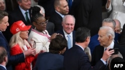 (De izq a der) La representante republicana Marjorie Taylor-Greene lleva un sombrero MAGA cuando el presidente Joe Biden llega para pronunciar el discurso sobre el Estado de la Nación en el Capitolio de los Estados Unidos en Washington, DC, el 7 de marzo de 2024. .
