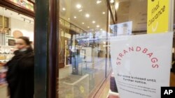 A woman walks past a closed store in Sydney, Wednesday, July 7, 2021. Sydney's two-week lockdown has been extended for another week due to the vulnerability of an Australia population largely unvaccinated against COVID-19, officials said. (AP Photo…