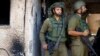 Los soldados observan cerca de una casa destruida a balazos, tras el mortal ataque del 7 de octubre perpetrado por hombres armados de Hamás desde la Franja de Gaza, en el kibutz Kfar Aza, en el sur de Israel, el 2 de noviembre de 2023.