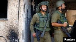Los soldados observan cerca de una casa destruida a balazos, tras el mortal ataque del 7 de octubre perpetrado por hombres armados de Hamás desde la Franja de Gaza, en el kibutz Kfar Aza, en el sur de Israel, el 2 de noviembre de 2023.
