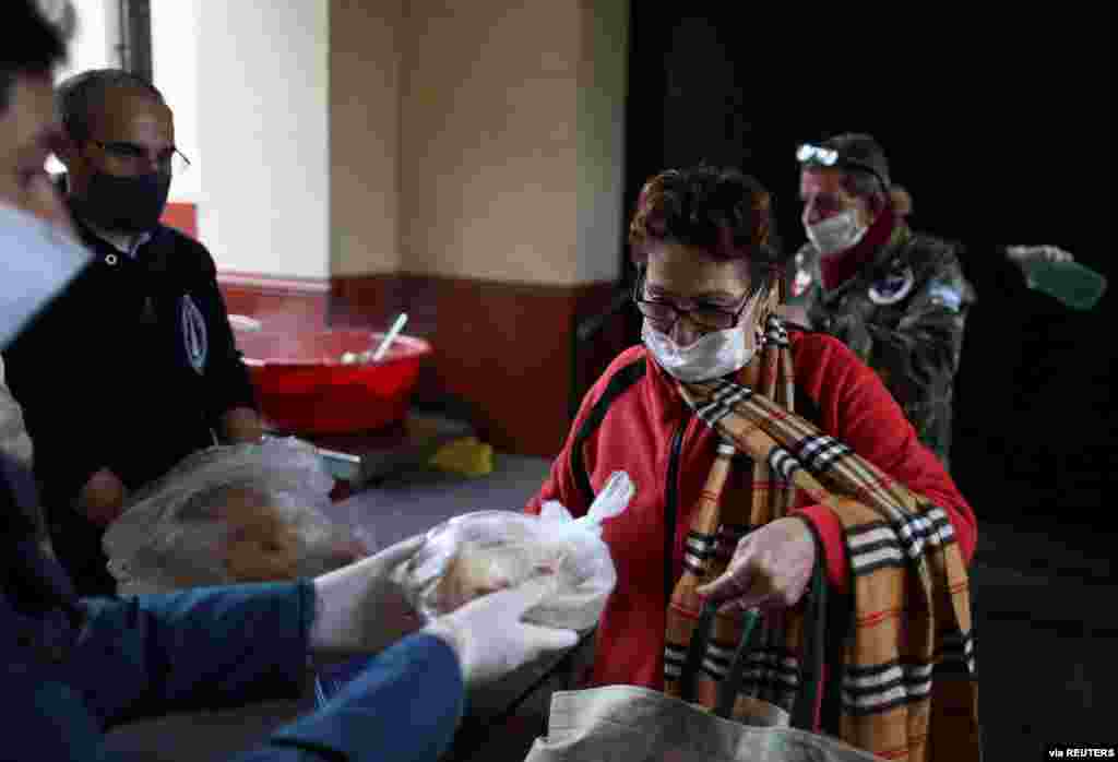 Durante estos tiempos de pandemia, muchas personas se han solidarizado con los más necesitados, brindado alimentos. En esta imagen una señora recibe pan frente a la Parroquia Nuestra Señora de Caacupé, en Buenos Aires, Aregentina.