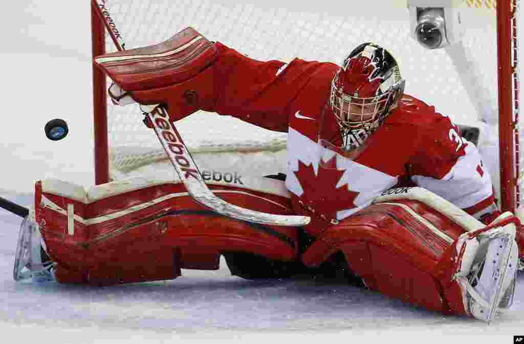 Goalkeeper Charline Labonte of Canada bats the puck away during the women's ice hockey game against the United States at Shayba Arena, Sochi, Russia, Feb. 12, 2014.