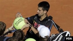 Novak Djokovic memberi tanda tangan kepada penggemarnya di Paris Terbuka bulan Mei silam. ((Foto:dok)