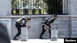 Members of Iranian forces take cover during an attack on the Iranian parliament in central Tehran, Iran, June 7, 2017. 