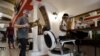 Workers wearing face masks to prevent the spread of COVID-19 prepare for the opening of a barbershop, in Rome, May 16, 2020. 