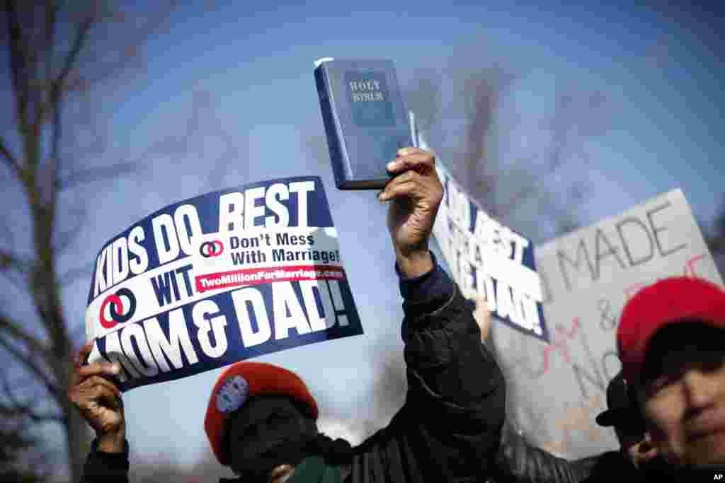 Seorang demonstran memegang alkitab sambil berbaris di luar gedung Mahkamah Agung di Washington (26/3). (AP/Pablo Martinez Monsivais)