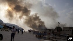 Karachining Jinna nomli xalqaro aeroportidan tutun chiqmoqda, xurujdan so'ng, Pokiston, 9-iyun, 2014-yil