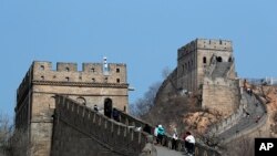 中國北京，在新型冠狀病毒爆發後重新開放的八達嶺長城上，遊客戴著防護口罩行走。