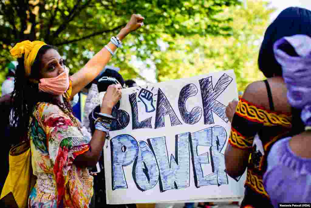 Une manifestante tient une pancarte "Black Power" lors du rassemblement "African4BLM" à Washington DC, le 14 juin 2020. (VOA/Nastasia Peteuil)