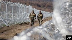 Des soldats macédoniens patrouillent à côté de la barrière de protection située le long de la frontière entre la Macédoine et la Grèce, près de la ville de Gevgelija, le vendredi 4 mars 2016.(AP Photo/Visar Kryeziu)