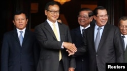 រូបឯកសារ៖ លោក សម រង្ស៊ី និងលោកនាយករដ្ឋមន្ត្រី ហ៊ុន សែន ចាប់ដៃគ្នា នៅមុខរដ្ឋសភា ក្រោយកិច្ចប្រជុំរួមគ្នាមួយ កាលពីថ្ងៃទី២២ ខែកក្កដា ឆ្នាំ២០១៤។