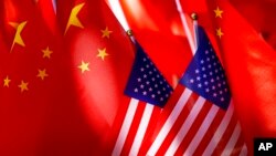 Bendera AS tampak berada di depan bendera China. Presiden Joe Biden mengatakan AS berada “dalam posisi terkuat dalam beberapa dekade untuk bersaing dengan China” baik secara ekonomi maupun militer. (Foto: Ilustrasi/AP)