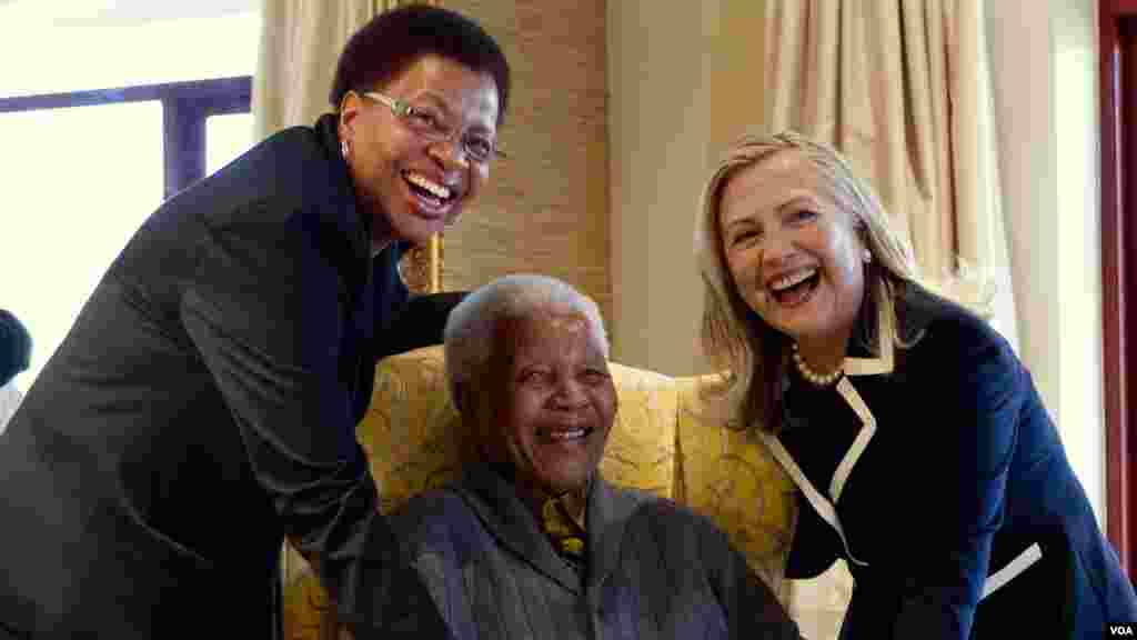 Nelson Mandela, 94, ancien président de l'Afrique du Sud, au centre et son épouse Graça Machel, à gauche, pose pour une photo avec la Secrétaire d'Etat américaine Hillary Clinton, à droite, à Qunu, Afrique du Sud, le 6 août 2012.