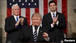FILE - US Vice President Mike Pence (L) and Speaker of the House Paul Ryan (R) applaud as US President Donald J. Trump (C) arrives to deliver his first address to a joint session of Congress on Feb. 28, 2017. (REUTERS/Jim Lo Scalzo)