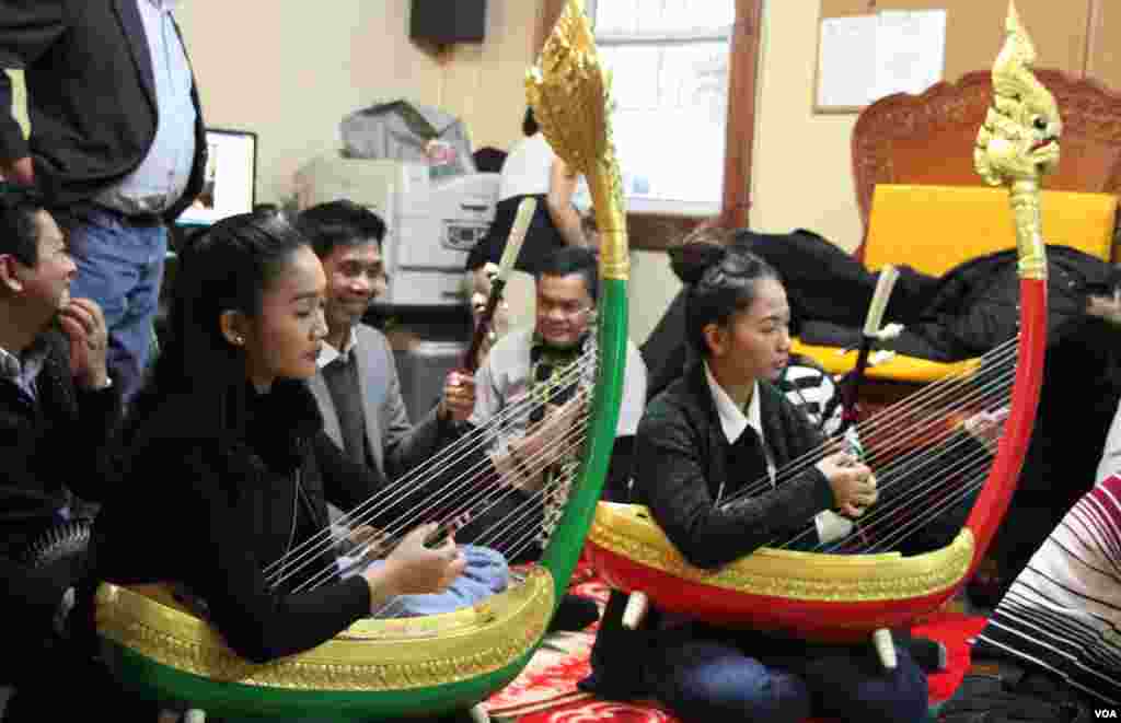 កញ្ញា ស្ងួន កវីស្រីរ័ត្ន និងកញ្ញា ពៅ រស្មីមុន្នី អ្នកដេញពិណនៃវង់តន្រ្តីស្នាដៃសិល្បៈ«បង្សុកូល»កំពុងសម្តែងនៅវត្តសាមគ្គីធម្មិការាម ក្នុងសង្កាត់ Brooklyn ទីក្រុង ញូវយ៉ក ដើម្បីបង្សុកូលដល់អ្នកដែលបានចែកឋានទៅក្នុងរបបខ្មែរក្រហម កាលពីថ្ងៃទី ១៧ ខែ ធ្នូ ឆ្នាំ ២០១៧។ (រូបថត៖ ហុង ចិន្តា/VOA)