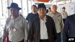 Foto distribuida por la Asociación Argentina de Trabajadores del Estado y la Unión Central de Trabajadores de Argentina, del expresidente boliviano Evo Morales (C) y el ex canciller boliviano Diego Pary Rodríguez (I) caminando a su llegada en el aeropuerto de Ezeiza, el jueves.