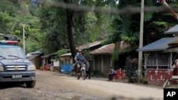 Warga setempat mengayuh sepeda motornya melewati pos polisi di Maungdaw, kota perbatasan di negara bagian Rakhine, Myanmar (Foto: dok). Para aktivis pendukung Rohingya melaporkan lebih darii 100 anggota komunitas muslim tersebut tewas dalam aksi kontra pemberontakan di negara bagian Rakhine baru-baru ini.