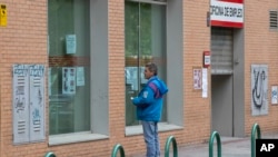 Un hombre lee los avisos en una oficina de empleo en Madrid, España, el martes 28 de abril de 2020.