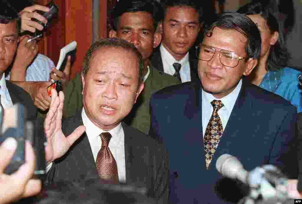 រូបឯកសារ៖ សម្ដេចក្រុមព្រះនរោត្តម រណឫទ្ធិ និងលោក ហ៊ុន សែន ដែលជាសហនាយករដ្ឋមន្ត្រីកម្ពុជា ថ្លែងនៅក្នុងសន្និសីទសារព័ត៌មានមិនគ្រោងទុកមួយនៅថ្ងៃទី ២១ ខែមិថុនា ឆ្នាំ ១៩៩៧ ដើម្បីបញ្ជាក់អំពីការចាប់ខ្លួនមេដឹកនាំខ្មែរក្រហមលោក ប៉ុល ពត។